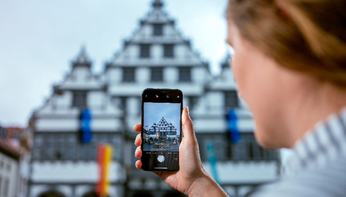 A woman takes a photo of a building