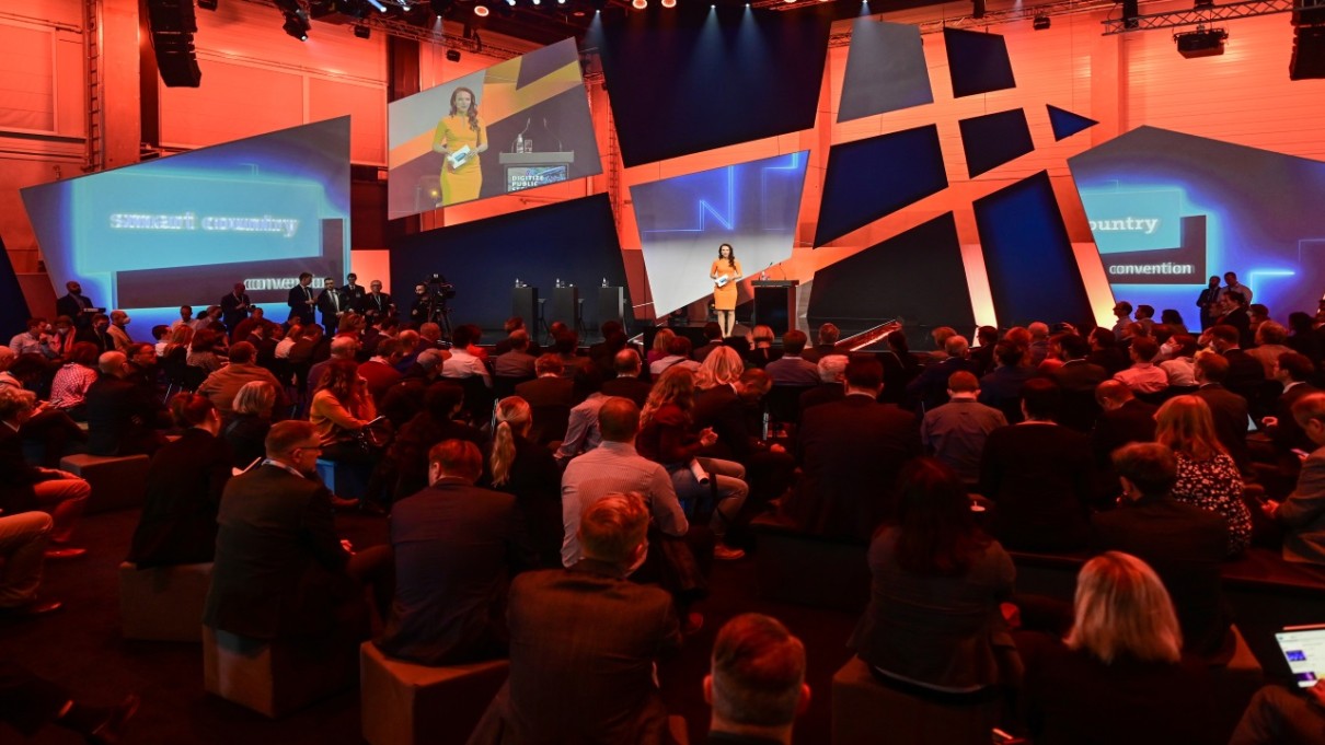 Plaza Stage of the Smart Country Convention, audience from behind in the foreground, moderator on stage in the background