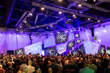 Eine große Menschenmenge vor der beleuchteten Plaza-Stage der Smart Country Convention 2023, auf der Bundesinnenministerin Nancy Faeser spricht. Eine große Menschenmenge vor der beleuchteten Plaza-Stage der Smart Country Convention 2023, auf der Bundesinnenministerin Nancy Faeser spricht.