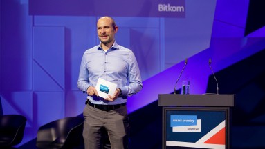 Man on stage at the Smart Country Convention with speaker cards in hand