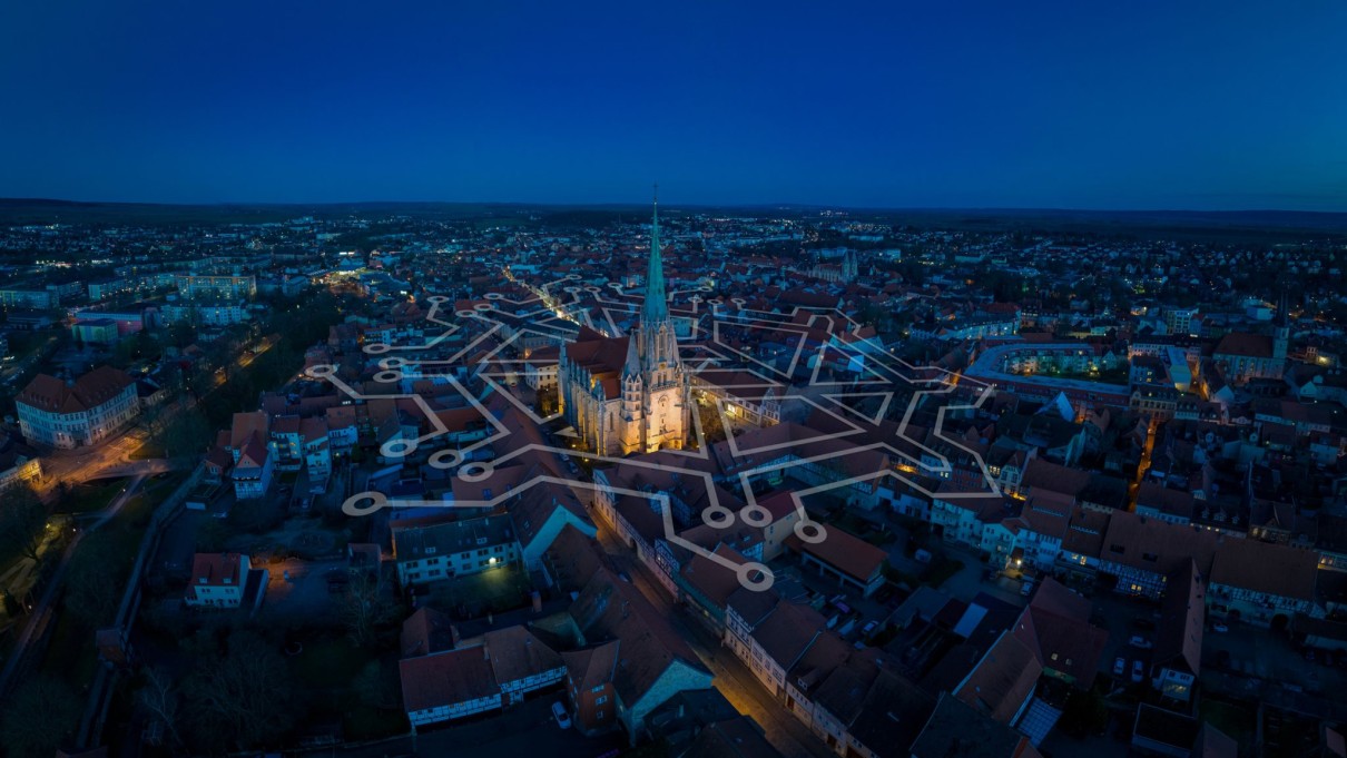 Nachtaufnahme der Stadt Mühlhausen mit einem grafischen Netz in der Mitte Nachtaufnahme der Stadt Mühlhausen mit einem grafischen Netz in der Mitte